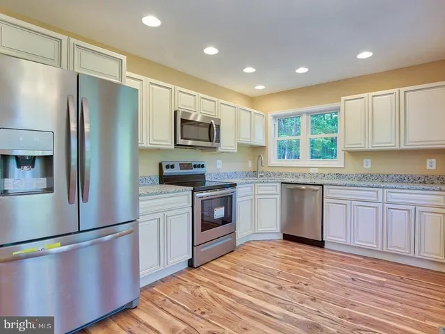 a kitchen with a refrigerator stove top oven and sink