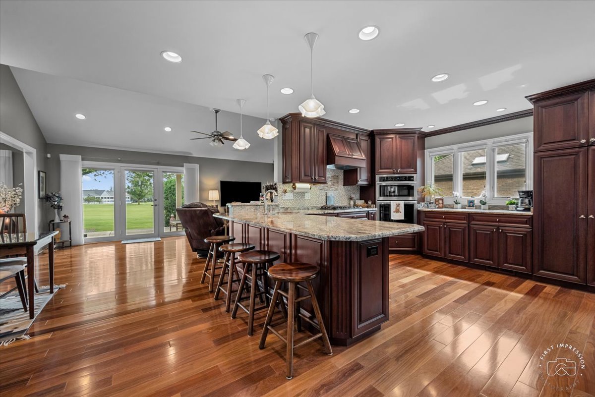 840 West Bauer Road Naperville, IL 60563 - Photo 23 of 37 a kitchen with stainless steel appliances kitchen island granite countertop a table chairs sink and cabinets
