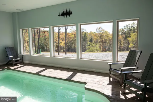 a living room with furniture a flat screen tv and a large window