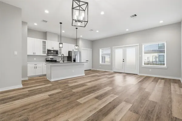 a view of an empty room with window and wooden floor