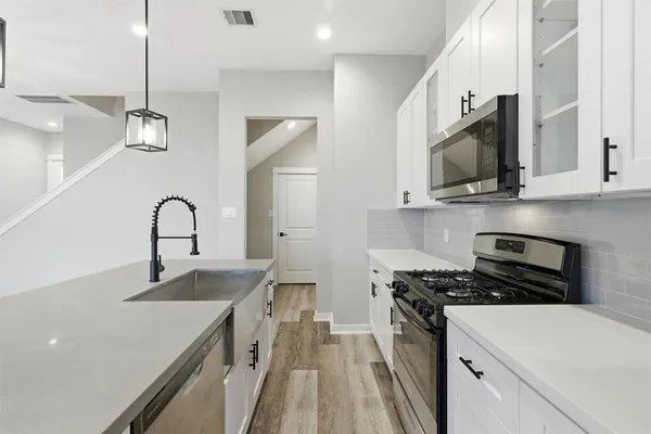 a kitchen with stainless steel appliances a refrigerator sink and microwave