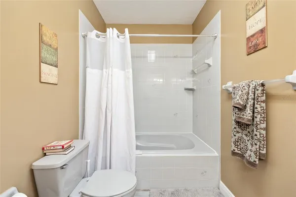 a bed sitting in a bedroom next to a window and a chandelier