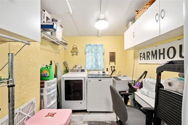 a view of a swimming pool with lawn chairs and potted plants