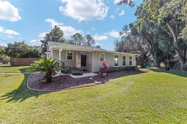 a view of a house with a backyard and a tree