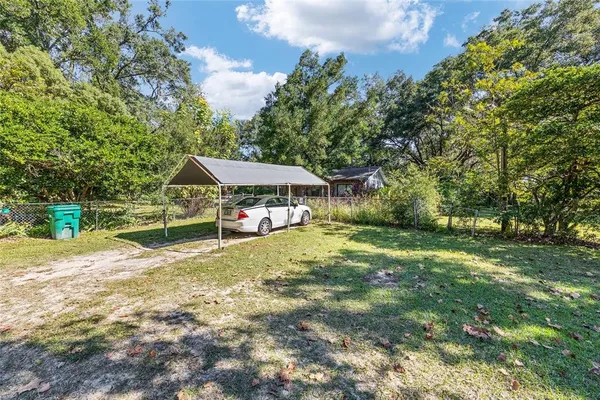 a view of a small yard and large trees