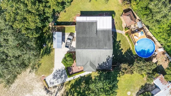 a view of a house with a yard and large trees