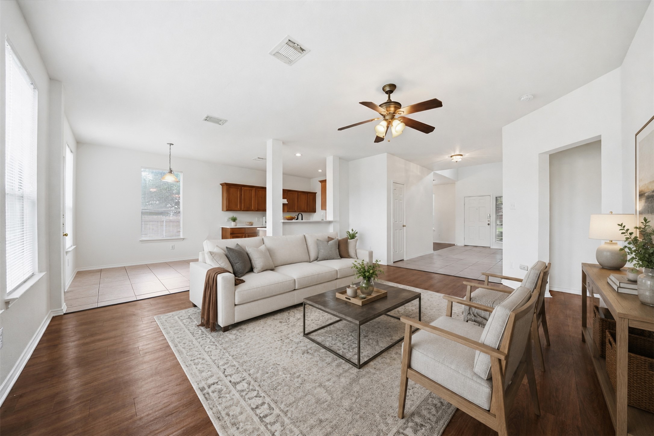 118 Invierno Street Kyle, TX 78640 - Photo 7 of 37 An inviting open-concept living area boasts rich hardwood flooring and a stylish ceiling fan.