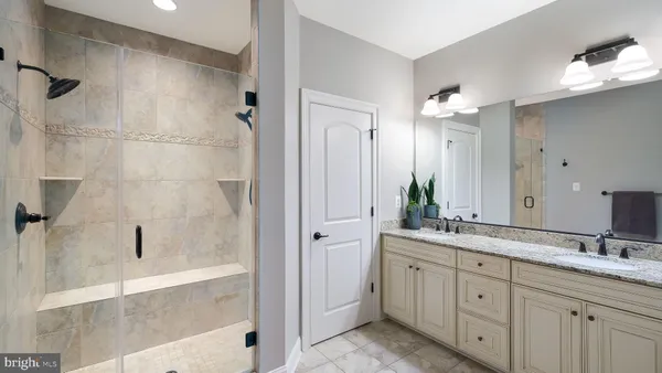 a spacious bathroom with a granite countertop sink mirror and shower