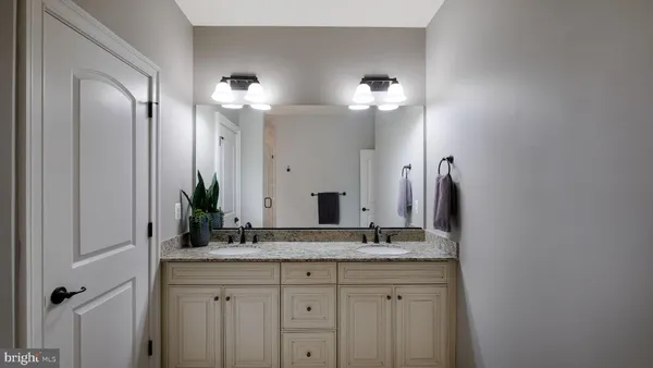 a bathroom with a double vanity sink and a mirror