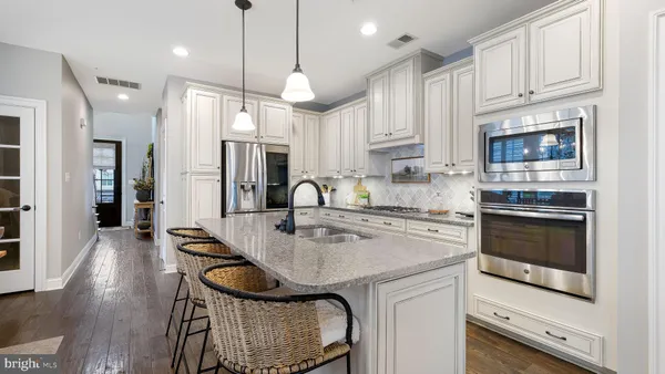 a kitchen with granite countertop a stove a sink and a refrigerator