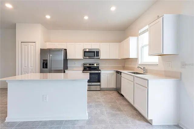 a kitchen with stainless steel appliances a refrigerator sink and microwave