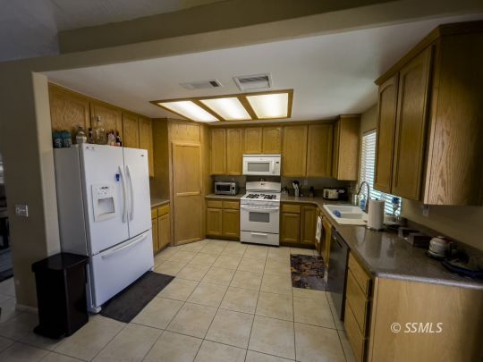 1411 Sims Street Ridgecrest, CA 93555 - Photo 8 of 35 a kitchen with cabinets and white appliances