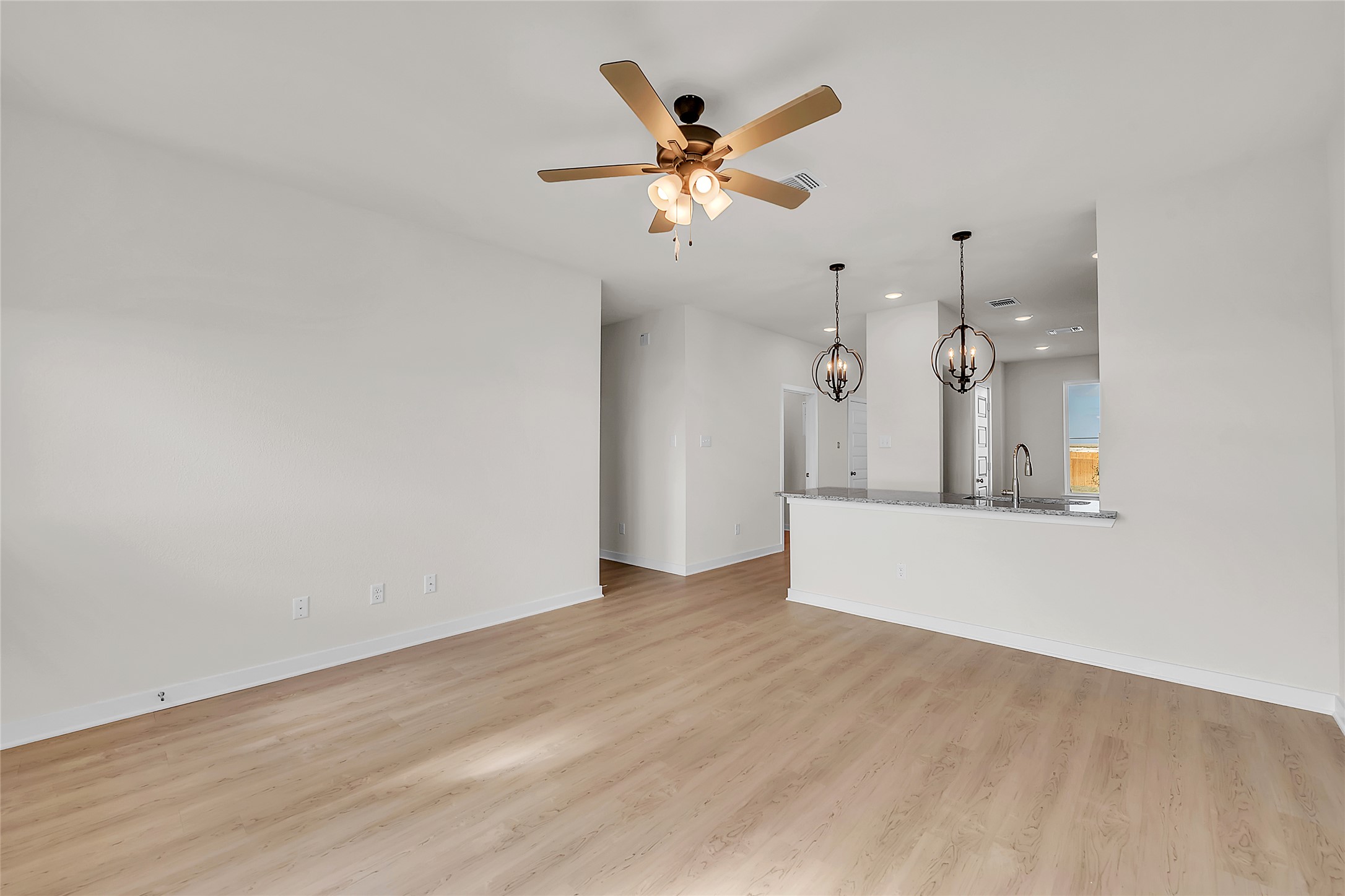308 Boatright Boulevard Jarrell, TX 76537 - Photo 20 of 31 Unfurnished living room with a chandelier, light wood-style floors, ceiling fan, and recessed lighting