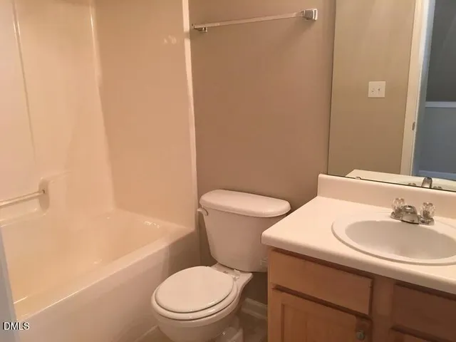 a white toilet sitting next to a bath tub