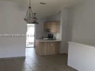 a view of a kitchen with an empty space and a window