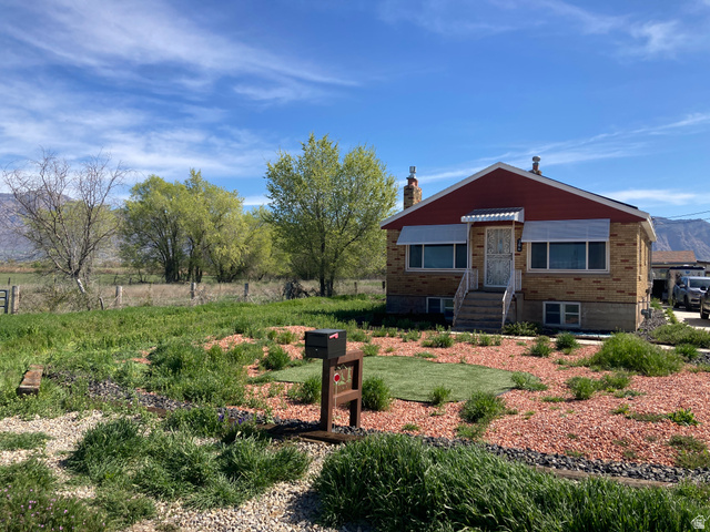 200 South 2800th Street West Ogden, UT 84404 - Photo 31 of 42 View of front of property with brick siding, a chimney, entry steps, and a mountain view