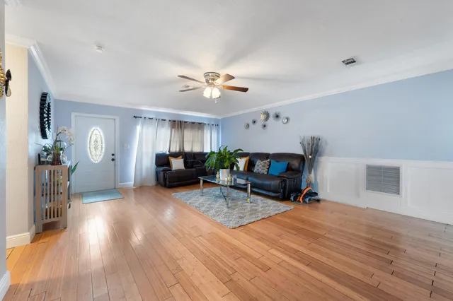 a living room with furniture a wooden floor and a chandelier