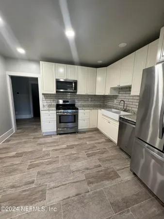 a kitchen with stainless steel appliances granite countertop a refrigerator sink and stove