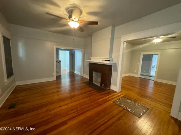 an empty room with wooden floor and fireplace