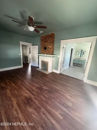 a view of a hallway with wooden floor and stairs