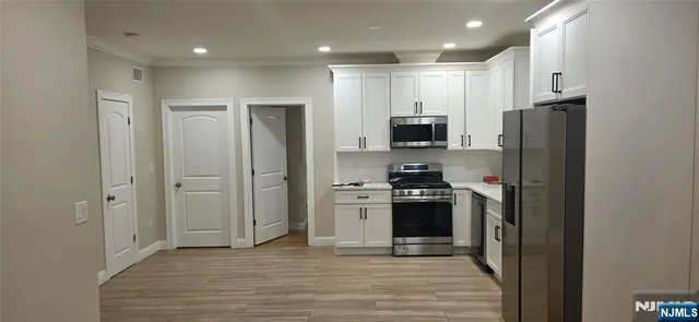 a kitchen with stainless steel appliances granite countertop a refrigerator stove and sink