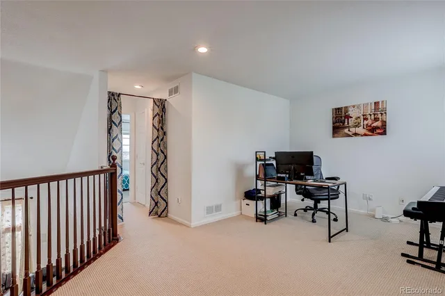 a view of a workspace with furniture and a ceiling fan