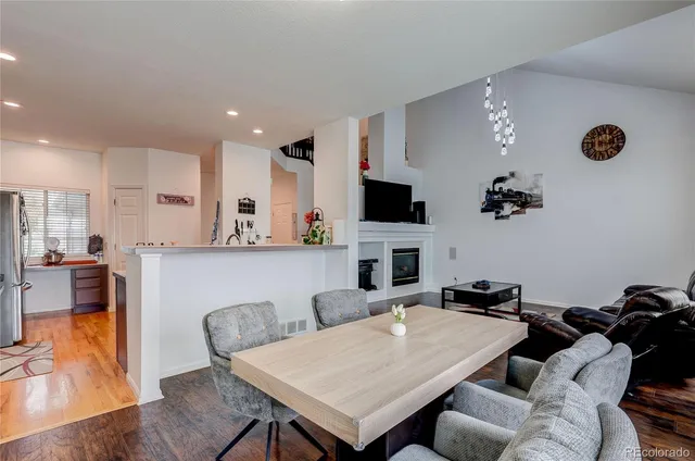 a living room with furniture a flat screen tv and kitchen view