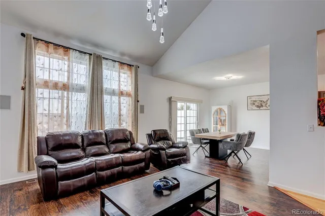 a living room with furniture a table and a large window