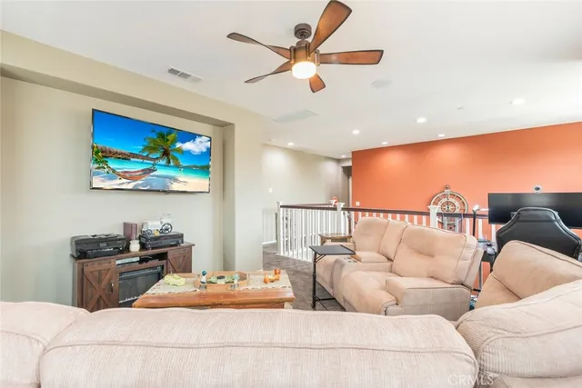a living room with furniture ceiling fan and a rug