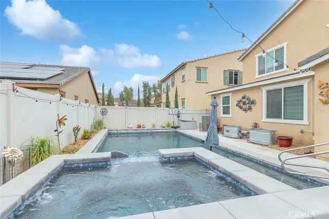 a view of a patio with couches and table and chairs with wooden fence