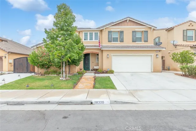 a front view of a house with a yard and trees