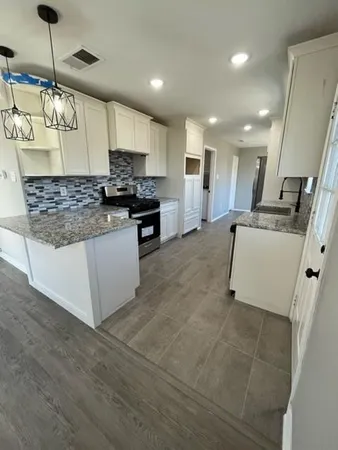 a large kitchen with a large counter top appliances and cabinets