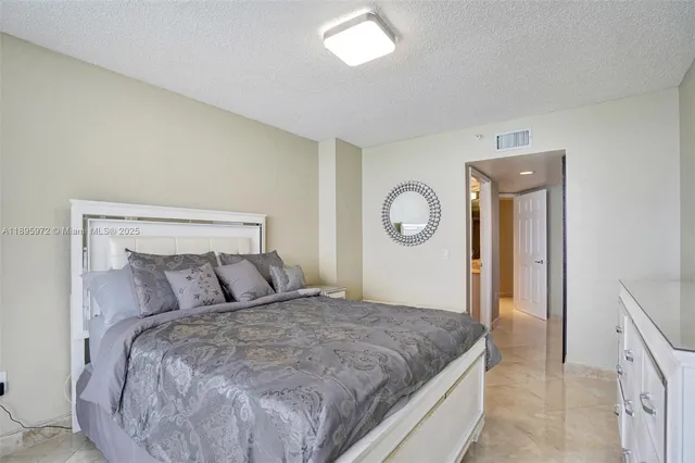 a bedroom with a large bed and a large mirror