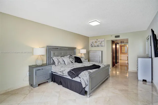 a bedroom with a bed and a refrigerator