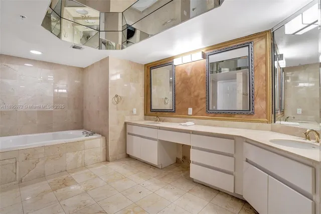 a bathroom with a sink a large mirror and a bathtub