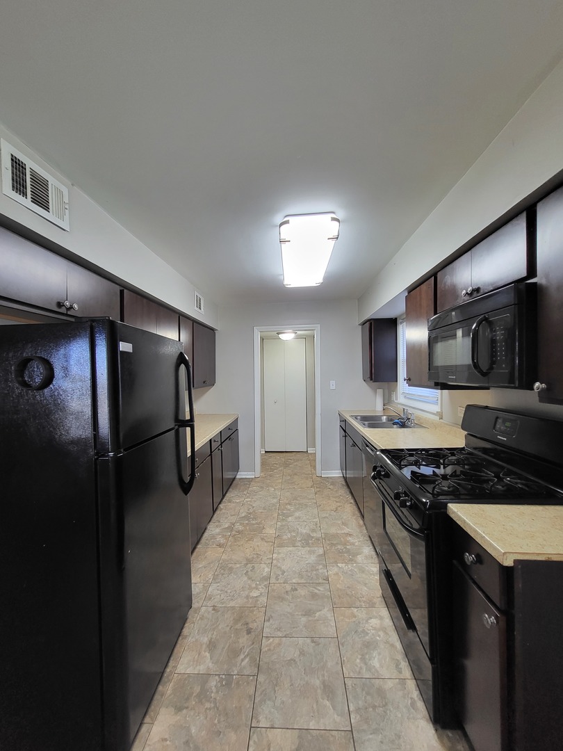 401 North Wolf Road Northlake, IL 60164 - Photo 3 of 15 a kitchen with stainless steel appliances granite countertop a stove a refrigerator and a sink