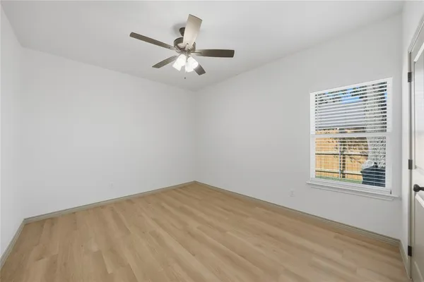 an empty room with a window and a fan