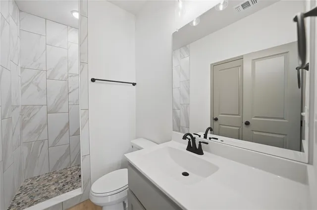 a bathroom with a sink a toilet and shower