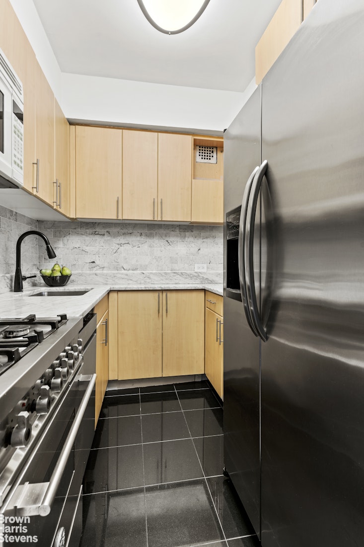 11 Riverside Drive, Unit 7PW Manhattan, NY 10023 - Photo 4 of 14 a kitchen with a refrigerator a sink and cabinets