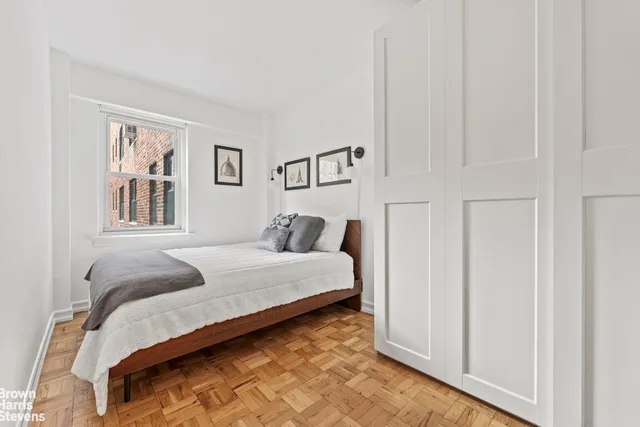 a bedroom with a bed and a painting on the wall