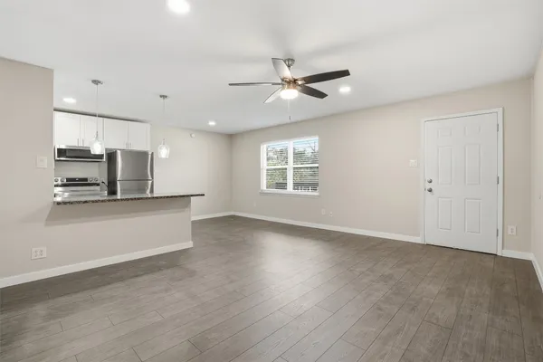 a kitchen with a refrigerator and white cabinets