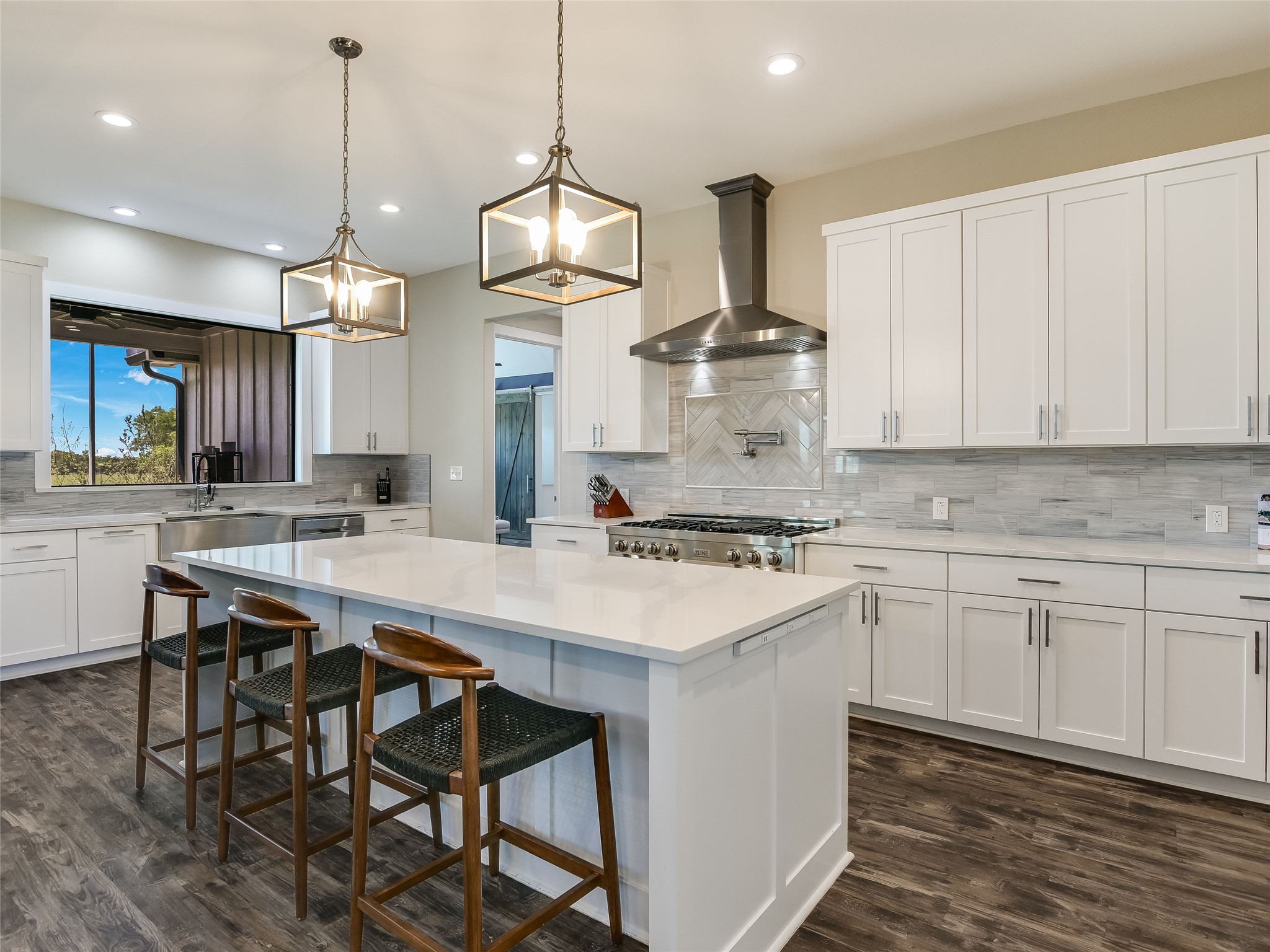 19819 Lockwood Road Manor, TX 78653 - Photo 7 of 29 The gourmet kitchen pairs crisp white cabinetry with a gas cooktop and pot filler, blending everyday functionality with designer finishes.