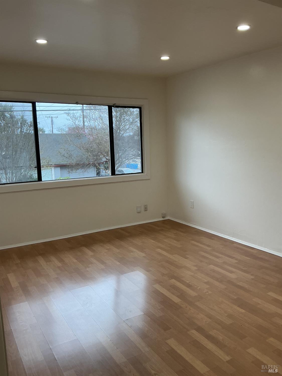212 South E Street, Unit B Santa Rosa, CA 95404 - Photo 2 of 31 an empty room with wooden floor and windows