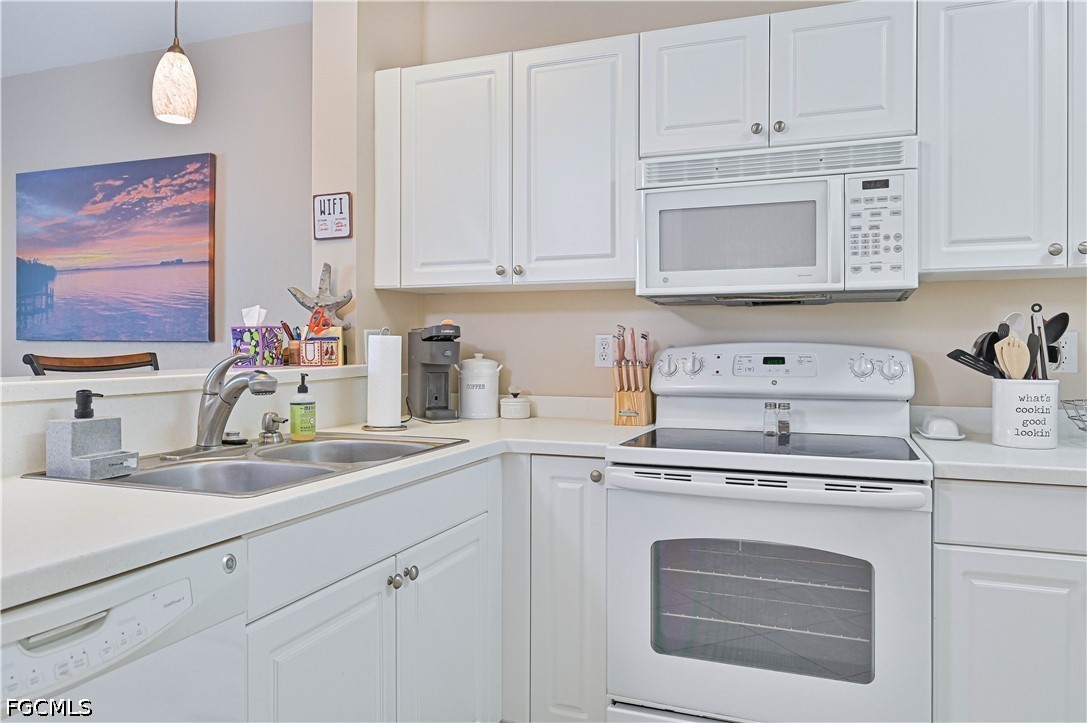 13120 Broadhurst Loop, Unit 505 Fort Myers, FL 33919 - Photo 13 of 28 a kitchen with white cabinets and white appliances