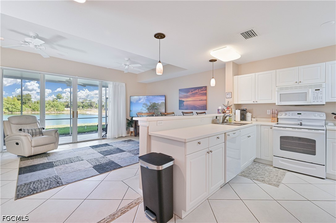 13120 Broadhurst Loop, Unit 505 Fort Myers, FL 33919 - Photo 8 of 28 a kitchen with a stove a sink and white cabinets with wooden floor