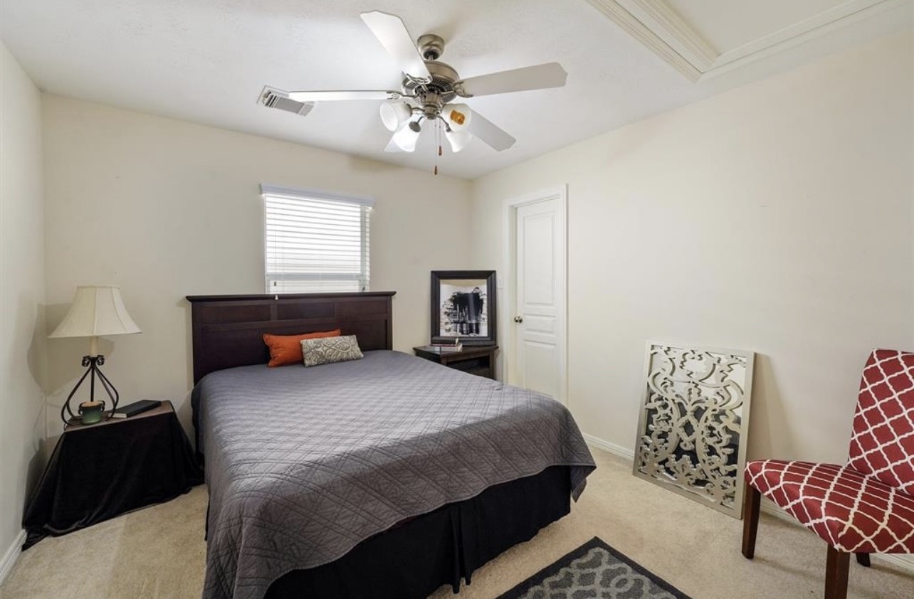 2646 Couch Street Houston, TX 77008 - Photo 14 of 21 a bedroom with a bed and a chandelier