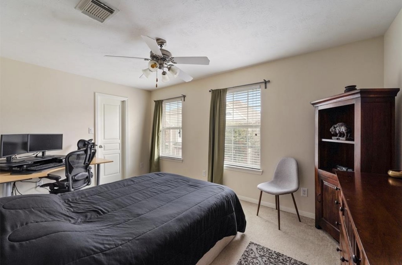 2646 Couch Street Houston, TX 77008 - Photo 15 of 21 a bedroom with a bed a chair and a chandelier