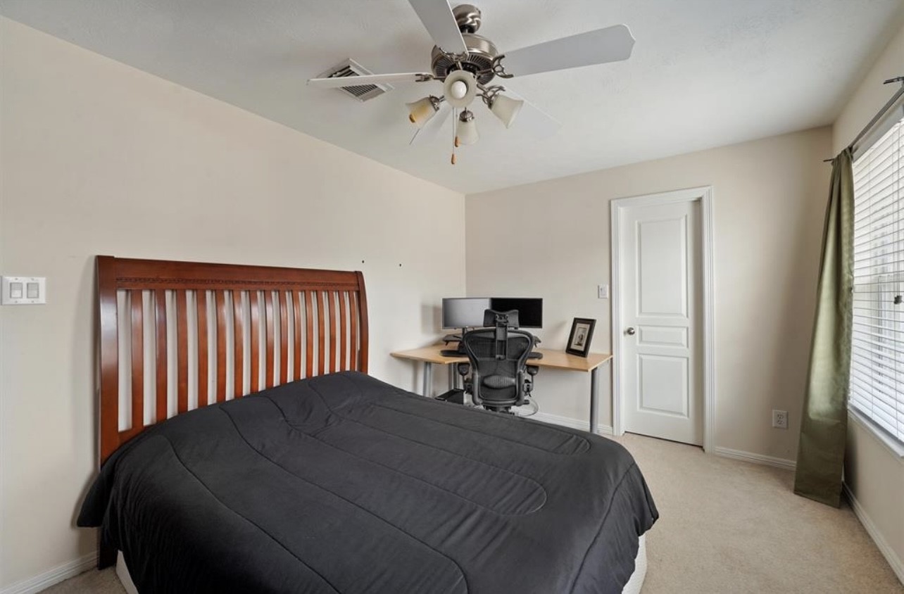 2646 Couch Street Houston, TX 77008 - Photo 17 of 21 a bedroom with a bed and a chandelier