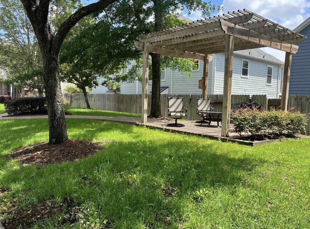 2646 Couch Street Houston, TX 77008 - Photo 19 of 21 a view of a backyard with table and chairs and a large tree