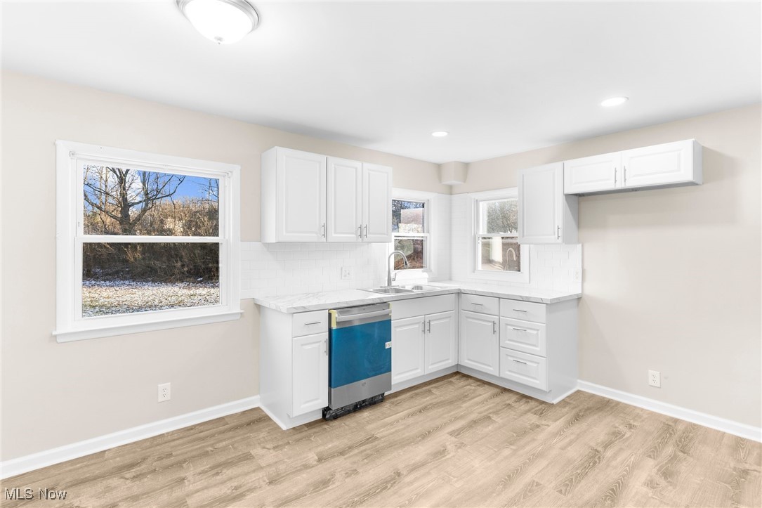 3441 Bell Wick Road Hubbard, OH 44425 - Photo 15 of 22 Kitchen with sink, tasteful backsplash, light hardwood / wood-style flooring, stainless steel dishwasher, and white cabinets